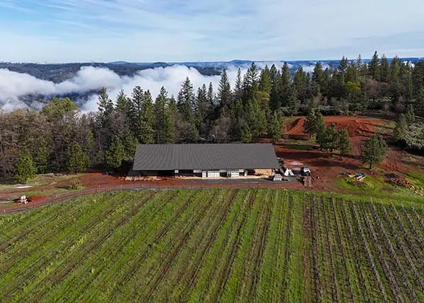 Aerial view of steel agricultural building on a hillside farm