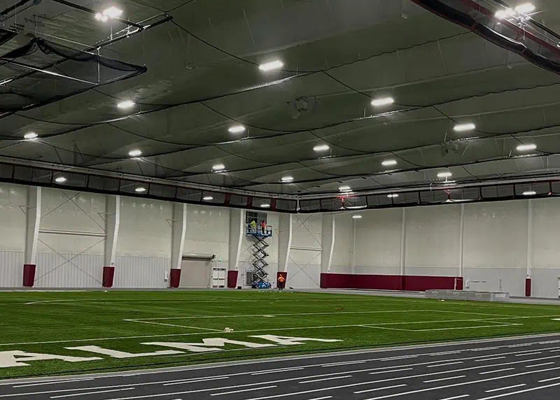 Large clear-span steel fieldhouse interior with turf field