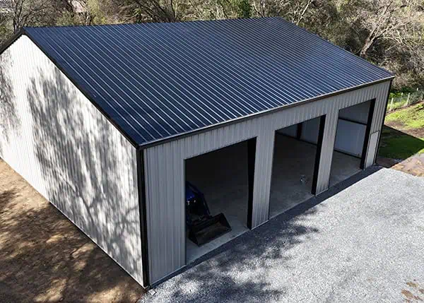 Three-bay steel garage with dark roof and open doors