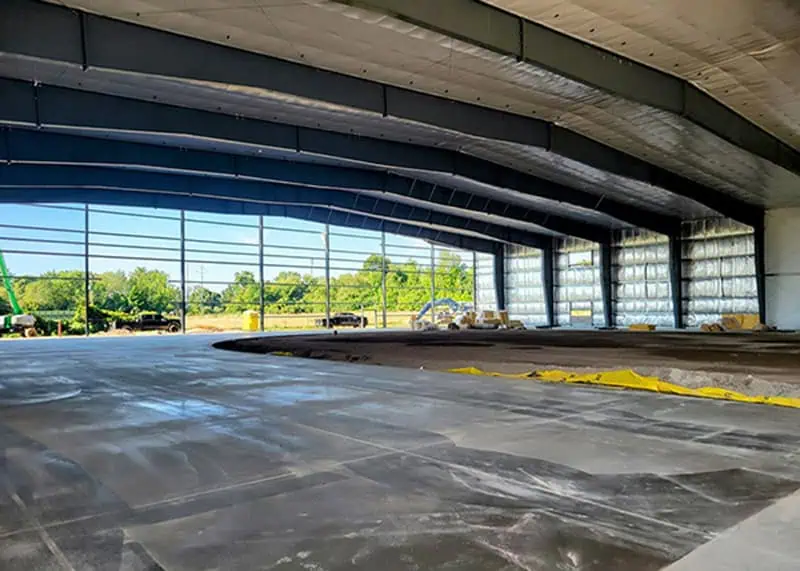 Large steel hangar interior with curved frame and full-width glazing