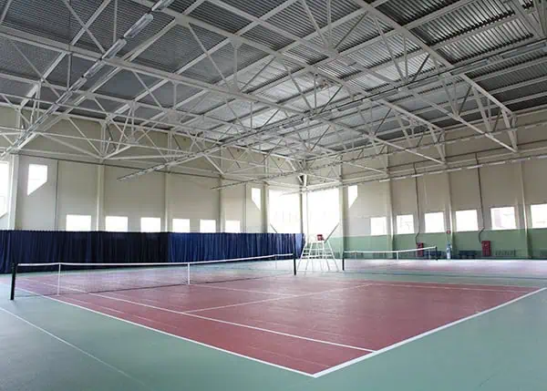 Indoor steel sports facility with tennis court and clear-span roof